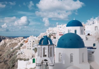 fotografia de casario branco com cúpulas azuis em Santorini